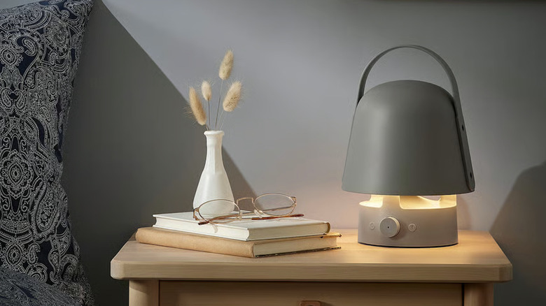 Portable grey lamp speaker on a nightstand
