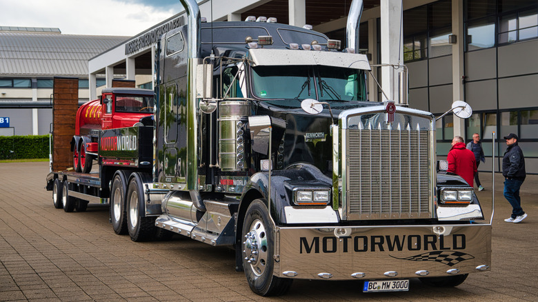 A black Kenworth W900 1961 conventional semi truck at a motor show