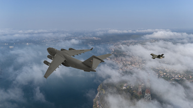 fighter jet and a C-17 flying together