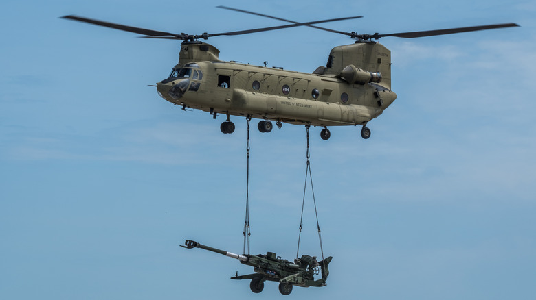 a Chinook carrying an artilery cannon