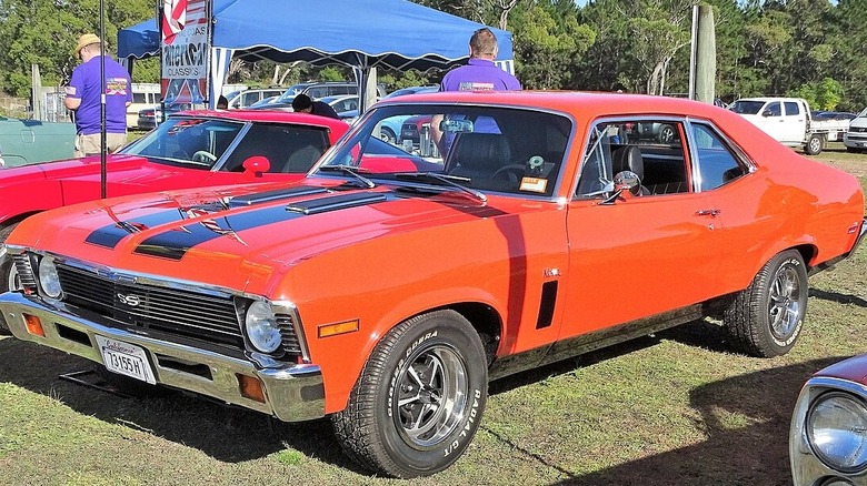 An orange Nova SS at a car show