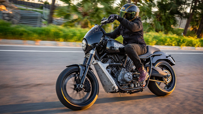 Man riding a black Buell Super Cruiser on the road