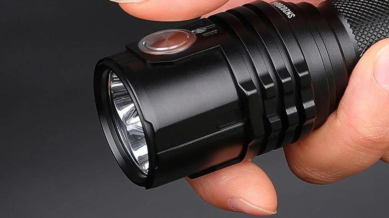 Close-up of a hand holding an Imalent flashlight