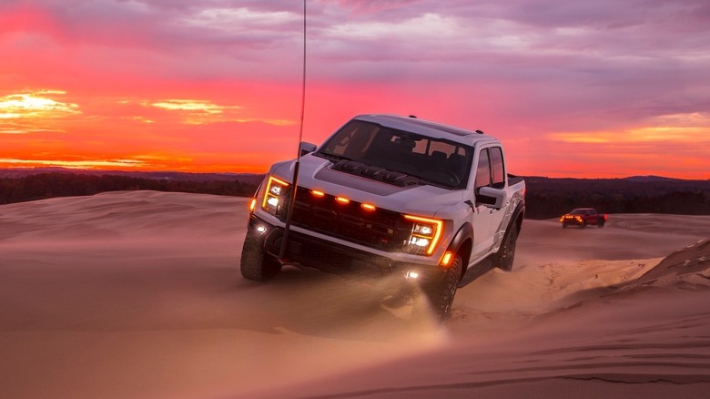 Ford F-150 Raptor R driving on sand dunes at sunset