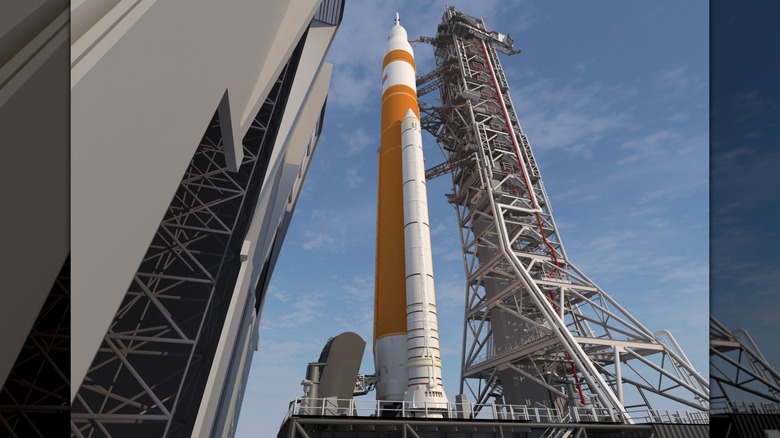 The SLS rocket rolling out of a building towards a launchpad