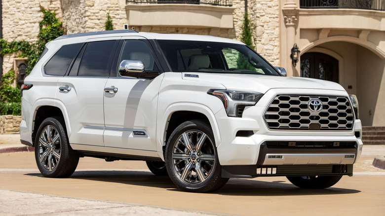 Wind Chill Pearl 2025 Sequoia Capstone parked on a paved surface in front of a building