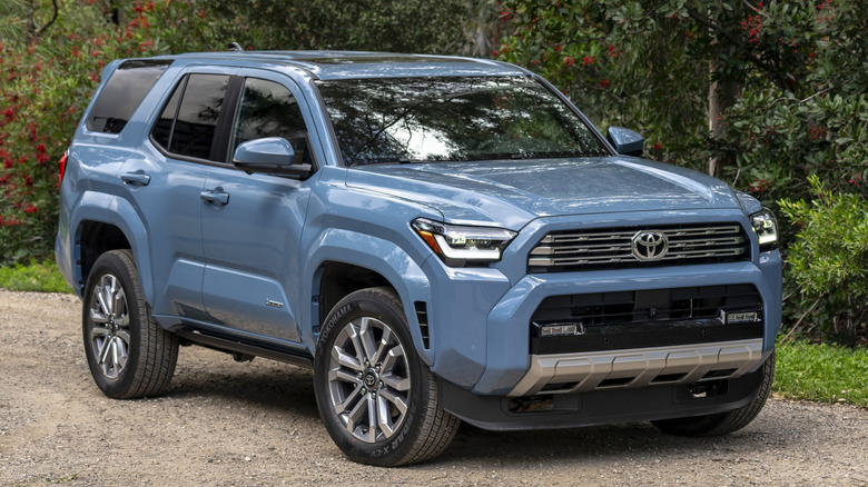 Front 3/4 view of Toyota 4Runner on dirt road in forested setting
