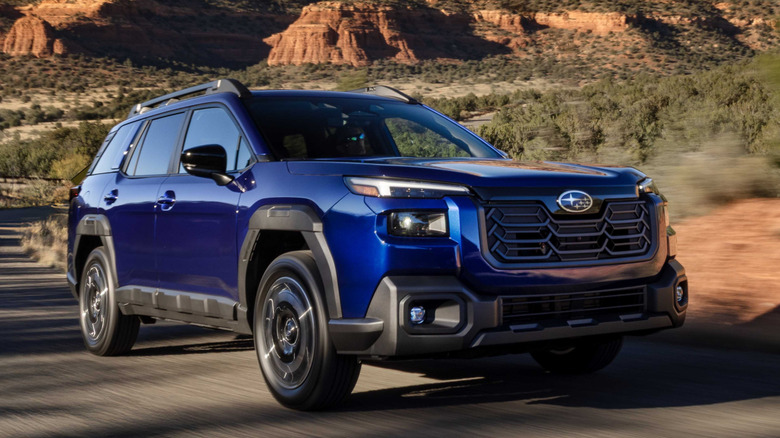 Front 3/4 view of Subaru Outback driving through desert terrain