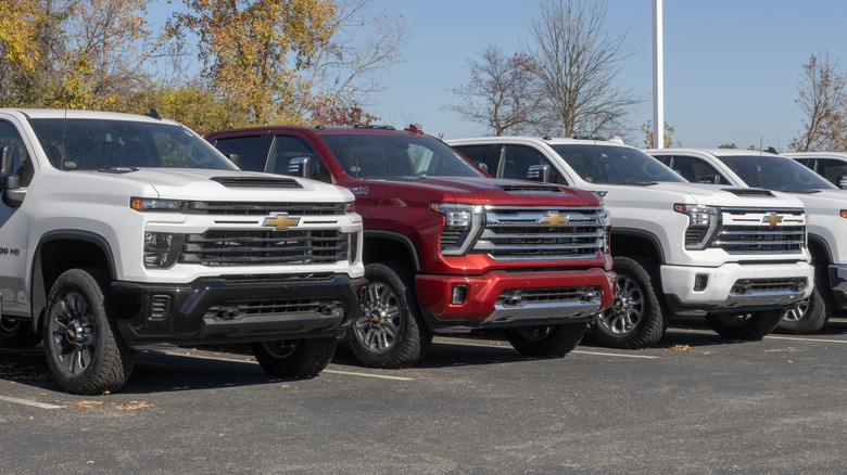Front view of Chevy Silverado 2500 pickup trucks lined up on dealer lot.