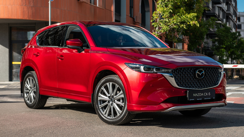 A red Mazda CX-50 parked in a street.