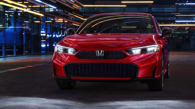 Front view of red Honda Civic Hybrid sedan parked at night.
