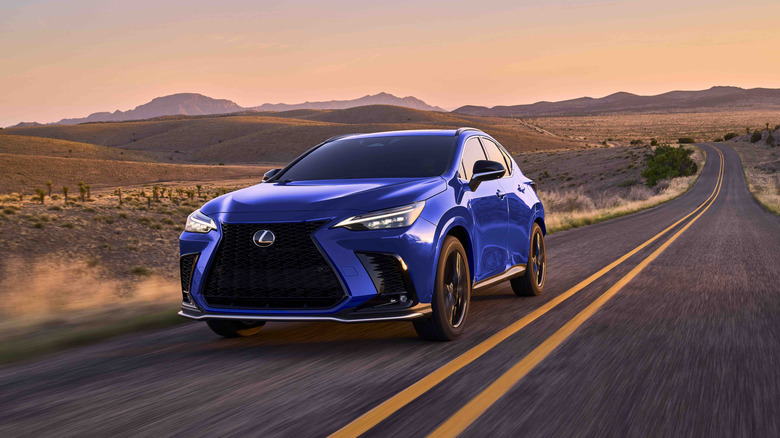 A blue 2025 Lexus NX 450h+ PHEV driving down an open desert road