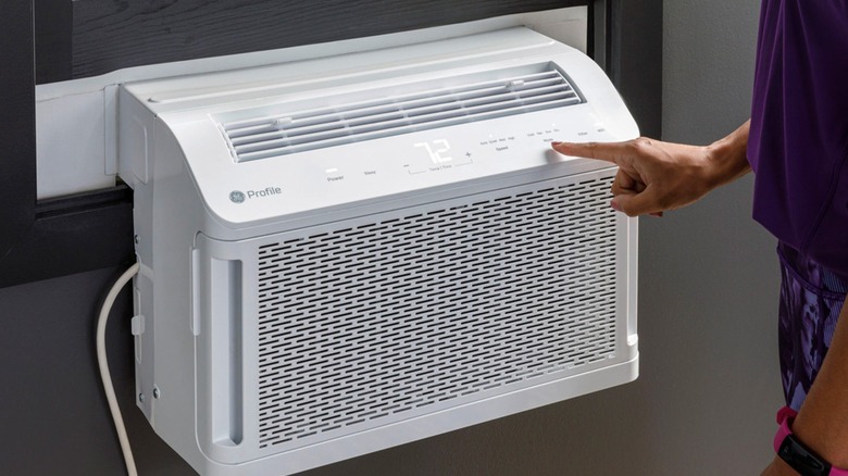 A person operating a GE air conditioner