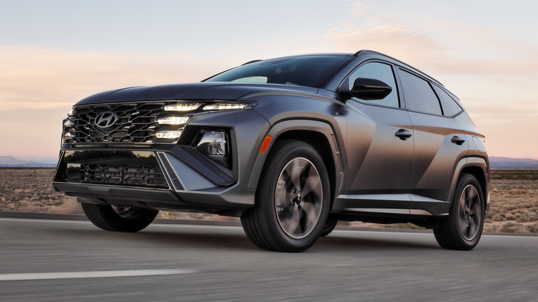 blue-gray 2026 Hyundai Tucson driving down a desert road