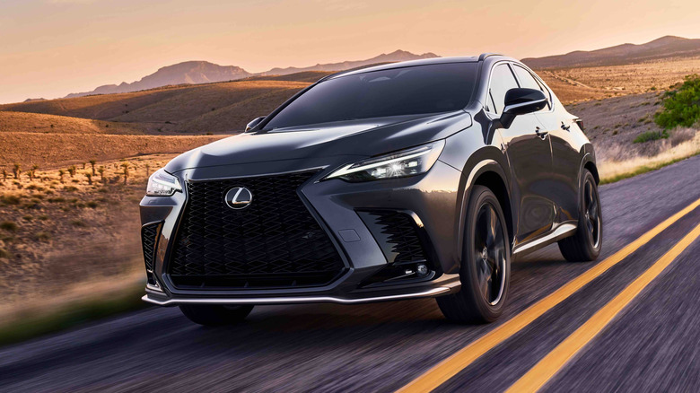 A gray 2026 Lexus NX F Sport driving down the road in the desert