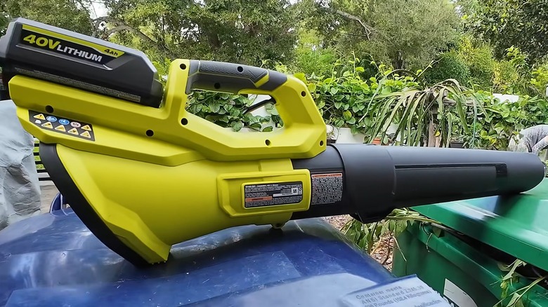 A Ryobi blower outside on a trash can.