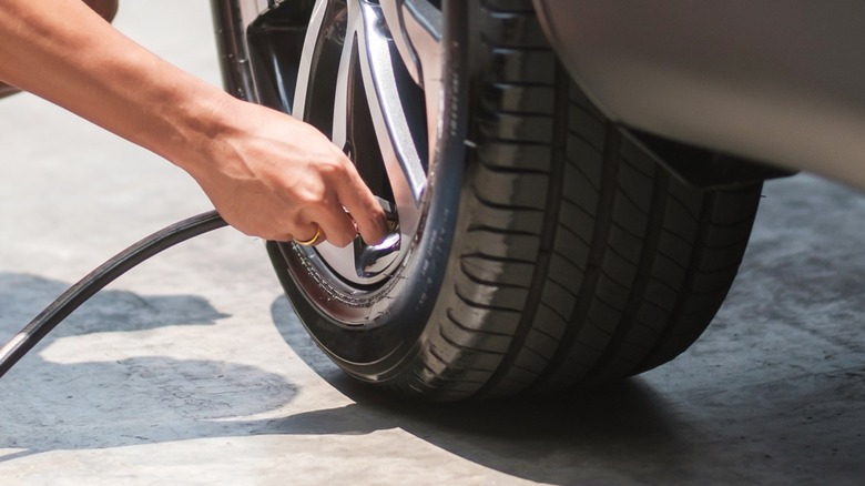 Individual putting air into tire with pump