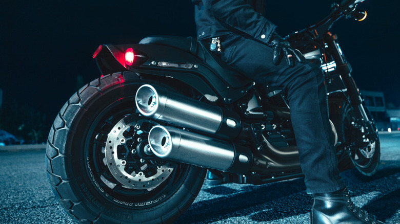 Rear-side view of the Harley-Davidson Fat Bob 114 stationary with a rider seated