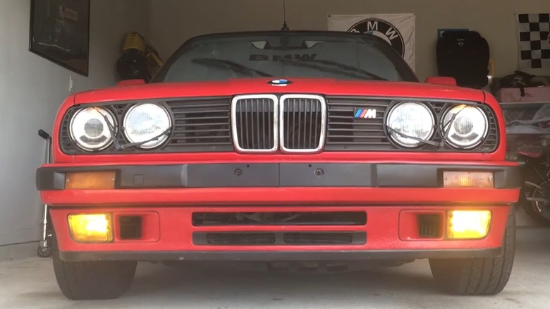 A red color BMW E30 325i with headlight wipers