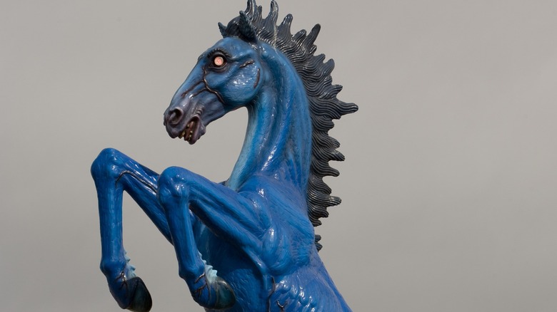 Statue of a blue horse with red LED eyes