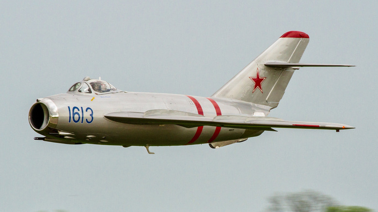 A MiG-17 takes off on a cloudy day