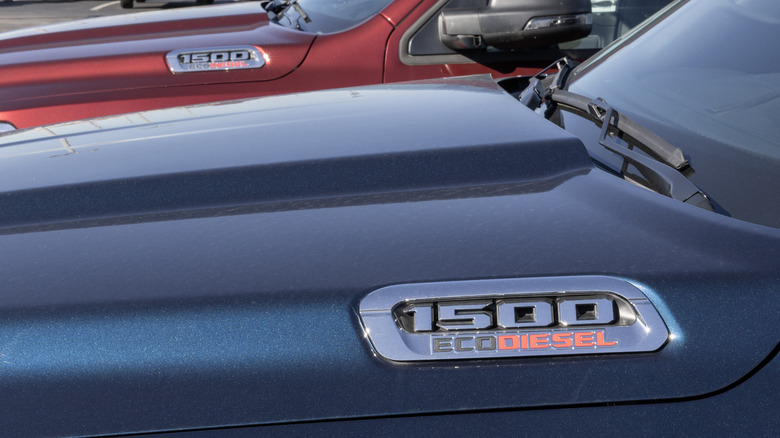 The hoods of red and blue Ram pickups showing '1500 EcoDiesel' chrome badges.