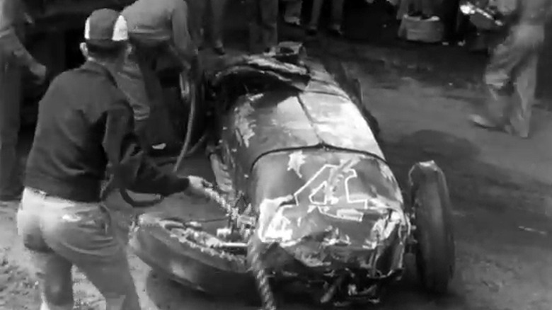 Bill Vukovich's race car post-accident being inspected by safety personnel, front-view