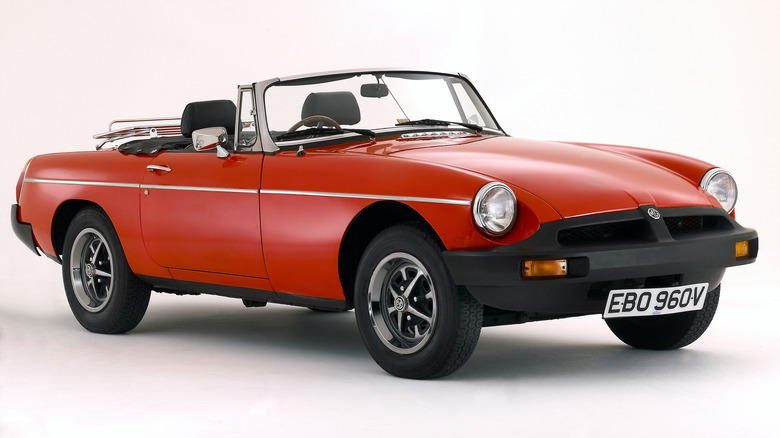Front 3/4 view of a red 1980 MGB convertible with hood down on a white background