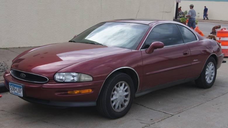 Maroon 1995 Buick Riviera parked in front of a building