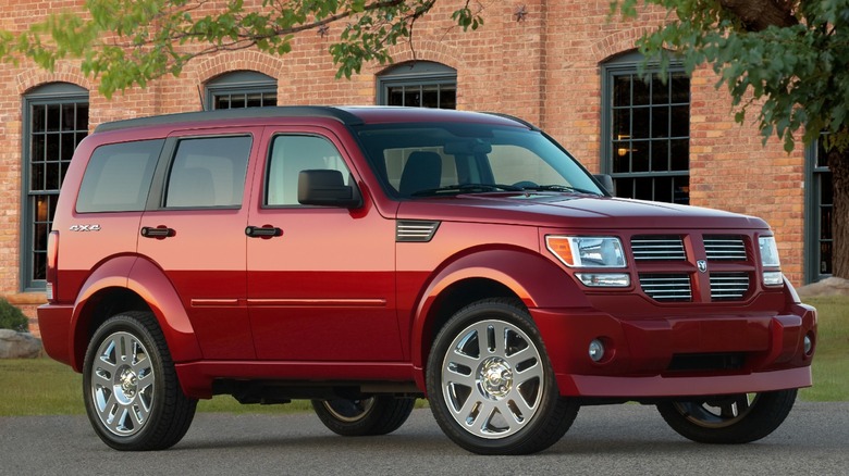 Red Dodge Nitro parked in front of a red brick building