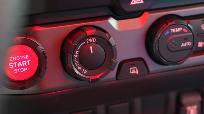 A black 4WD selector knob in a vehicle dashboard, currently set to a 2WD drive mode.