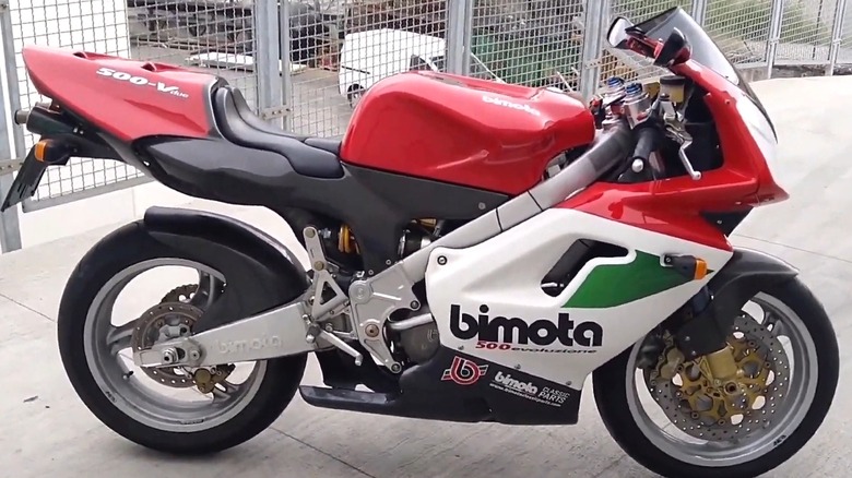 A Bimota 500 V-Due sport bike in red, white, and green livery, sitting on pavement with a race-inspired stance.