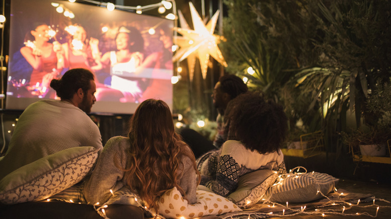 people enjoying projector movie night in a backyard