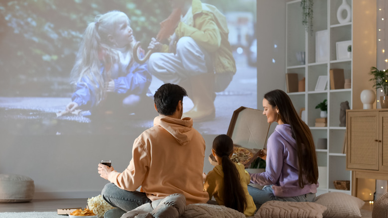 family using projector in living room