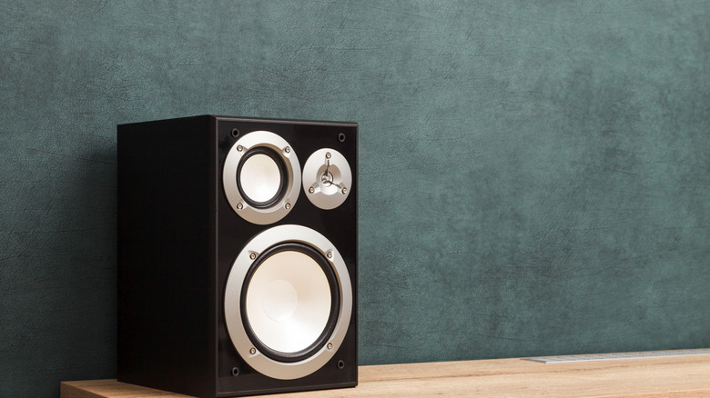 A subwoofer placed on top of a table and against a wall