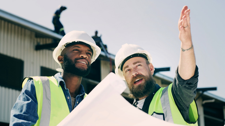 Two people discussing work on a construction site.