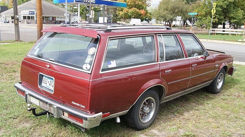 A red diesel-powered Station Wagon Oldsmobile seen from behind.