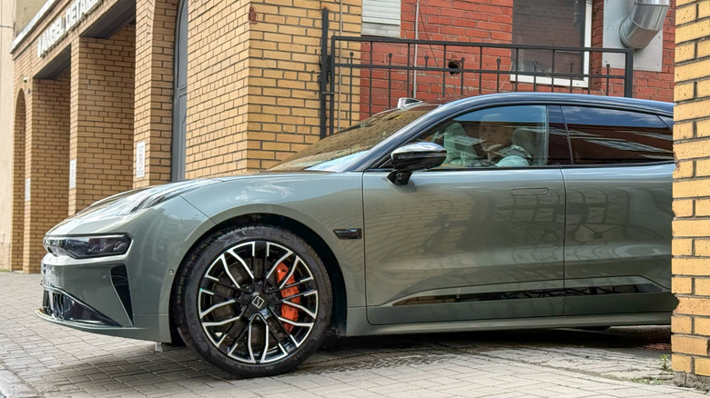 A sleek Zeekr 001 Electric car in shooting brake bodystyle cruising through a narrow city street