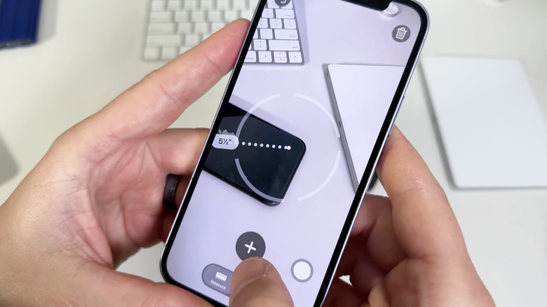 man using iPhone measuring app