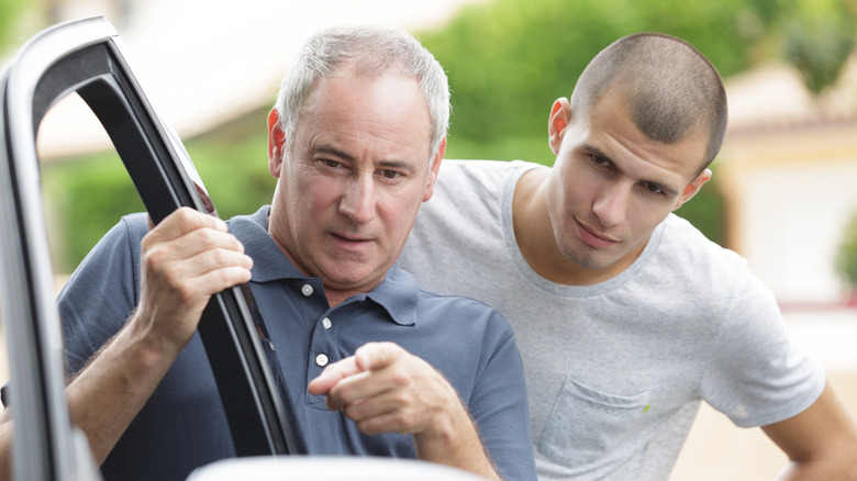 Father teaching his son about a car
