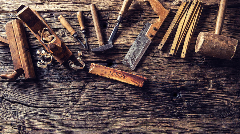 Old tools spread out on a wood surface.