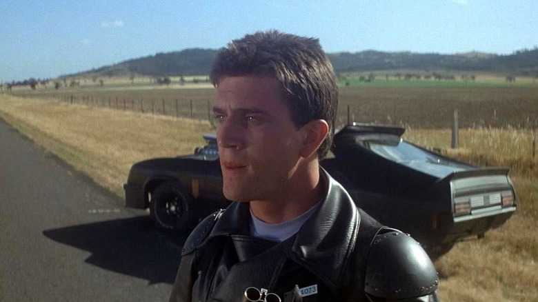 Max Rockatansky standing in the middle of the road in Mad Max (1979).
