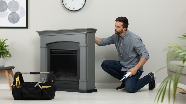 man installing electric fireplace