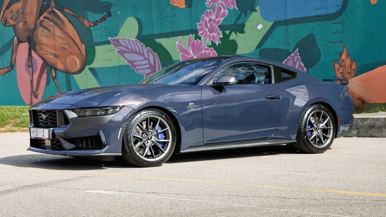 Ford Mustang Dark Horse in front of mural.