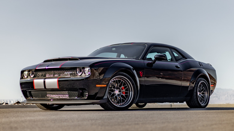 Black dodge demon parked under a grey sky.