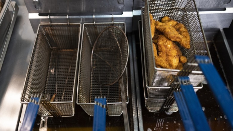 A deep fryer with some fried chicken