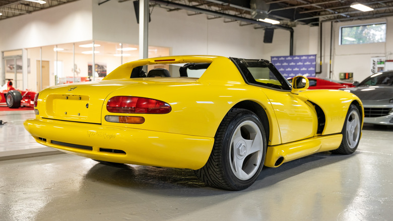 Rear 3/4 view of yellow Dodge Viper RT/10 parked in showroom.