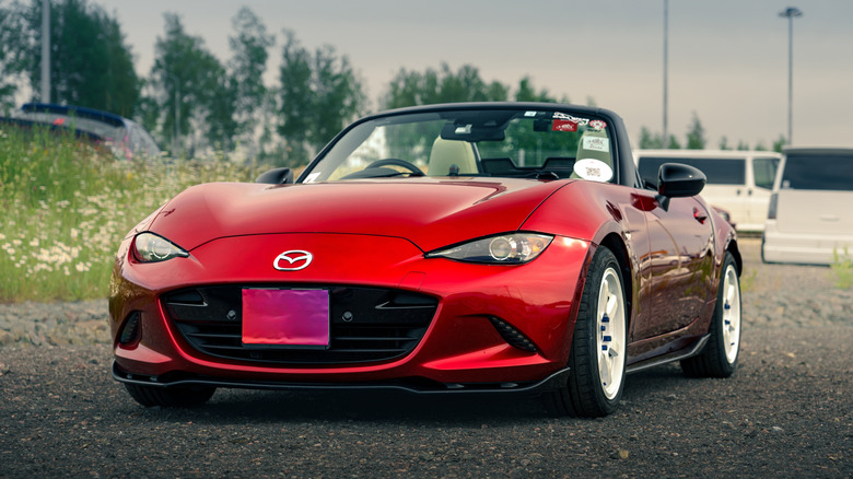 Front view of red ND Mazda MX-5 Miata parked in parking lot.