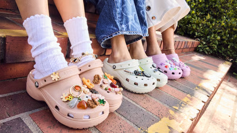 A group of kids wearing Cros with a bunch of Jibbitz charms on them