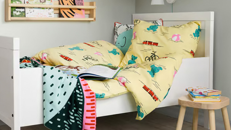 An Ikea bed with pillows and covers strewn about.
